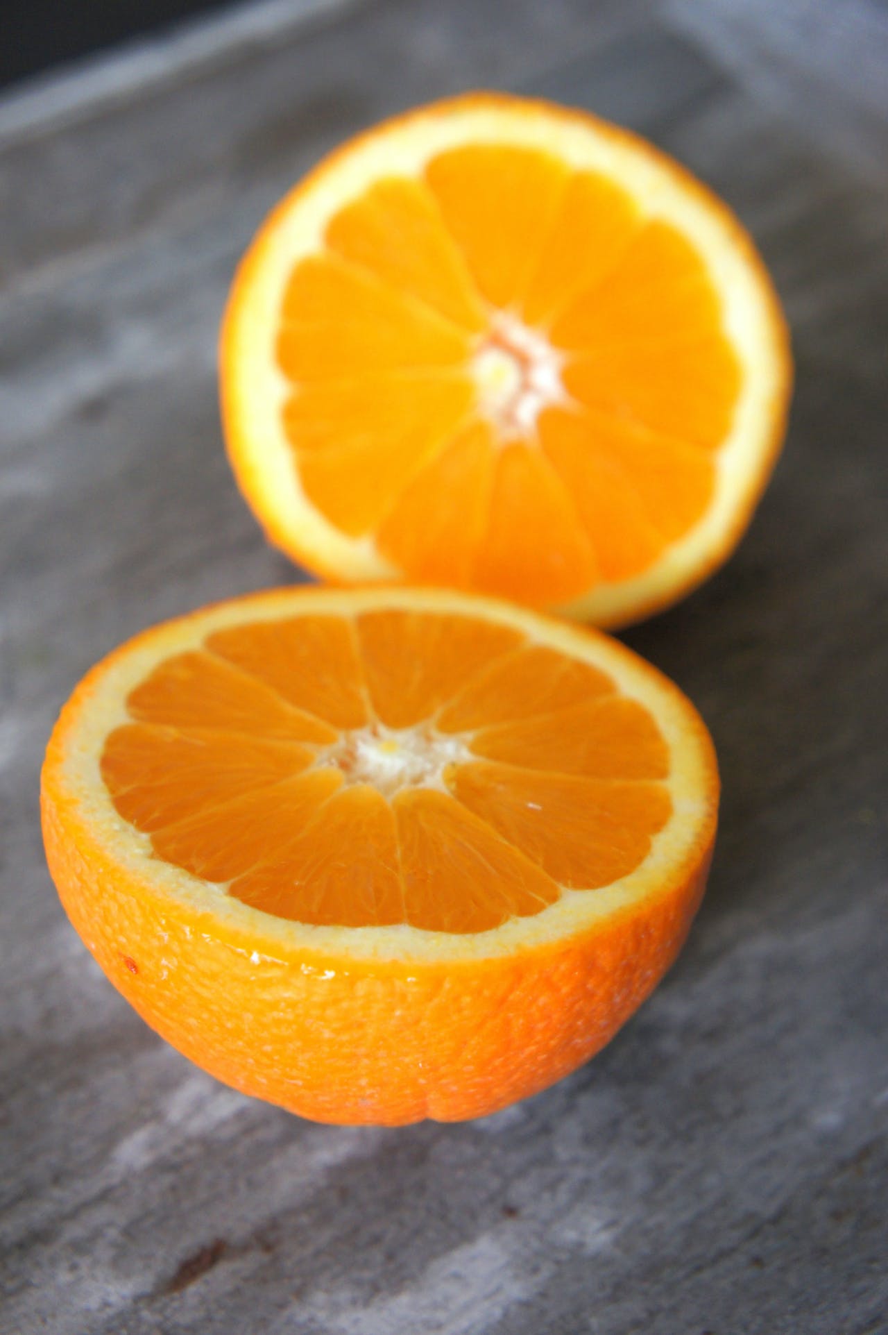 Una naranja partida en dos encima de una encimera gris